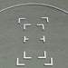 White L-shaped and T-shaped training markers on a grey sports court surface with a curved boundary line.