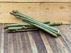 Green and brown willow cuttings for plant propagation on a wooden table. Light wood crate background.