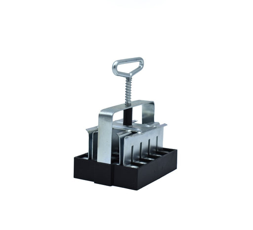 Silver metal and black plastic soil blocker for creating seedling soil blocks.